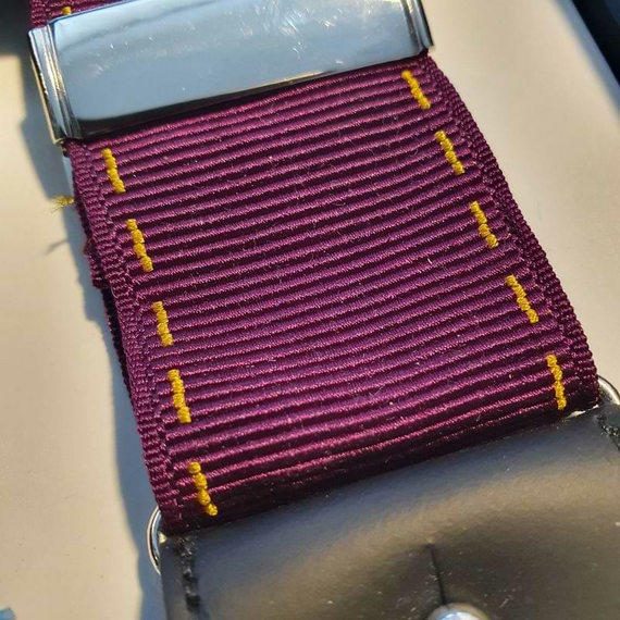 Hosentrger von Albert Thurston fr Tiger & Capricorn mit violetten Bndern und unterbrochenen Gold-Linien. Die Bnder liegen unter einer dunkelblauen Banderole auf der 