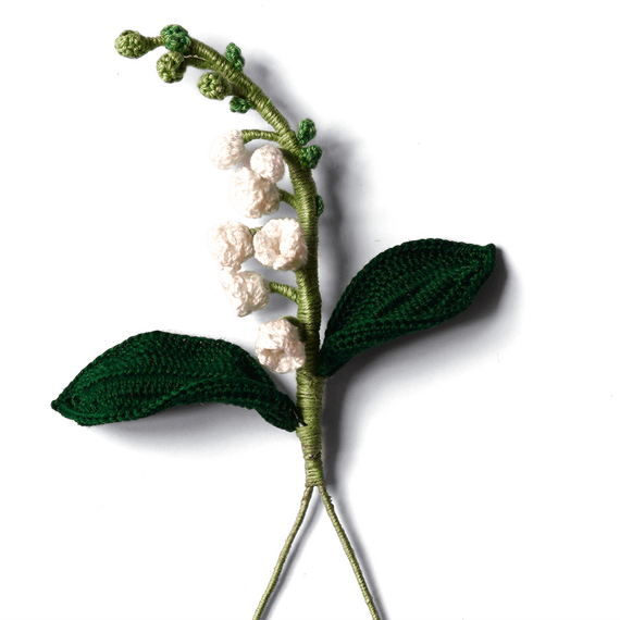 Boutonniere eines gehäkelten weißen Maiglöckchens in der...