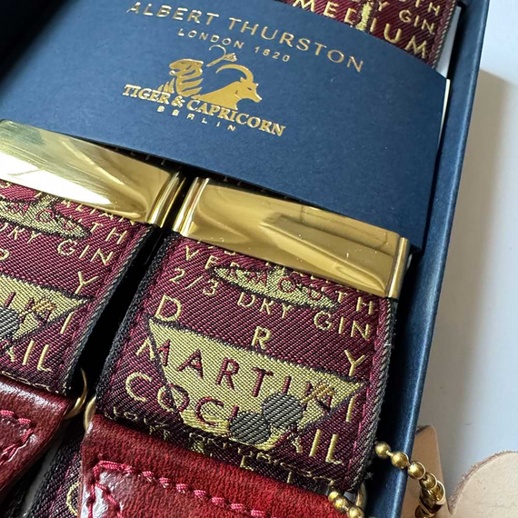 Detail der goldfarbenen Versteller und eingewebten Martini-Schrift auf dem Albert Thurston Booze.